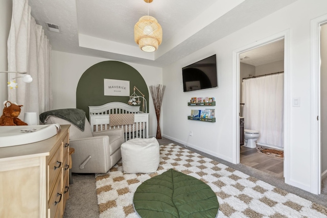 bedroom with visible vents, carpet flooring, a raised ceiling, and baseboards