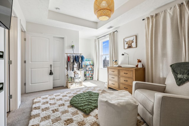 living area featuring a raised ceiling, carpet flooring, and visible vents