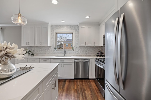 kitchen with a sink, decorative light fixtures, dark wood-style floors, white cabinetry, and stainless steel appliances