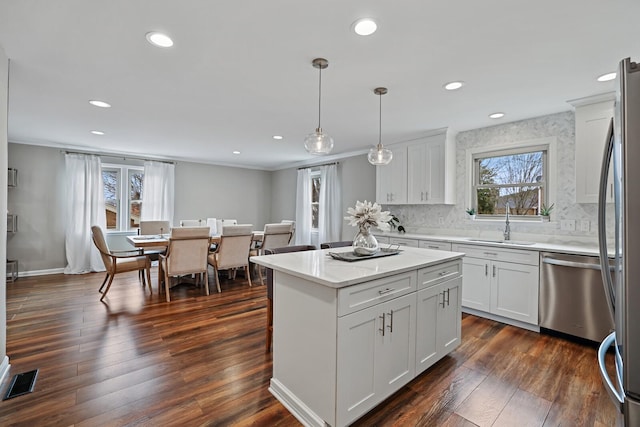 kitchen with visible vents, dark wood-style flooring, a sink, white cabinets, and appliances with stainless steel finishes