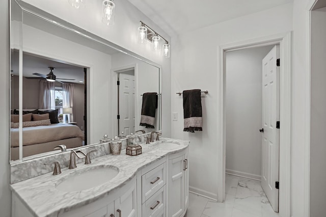 ensuite bathroom with a sink, connected bathroom, baseboards, and marble finish floor