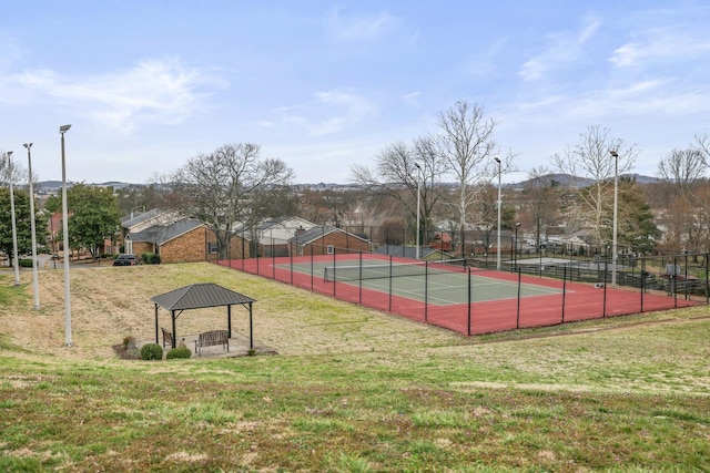 view of sport court with a gazebo, a mountain view, a lawn, and fence