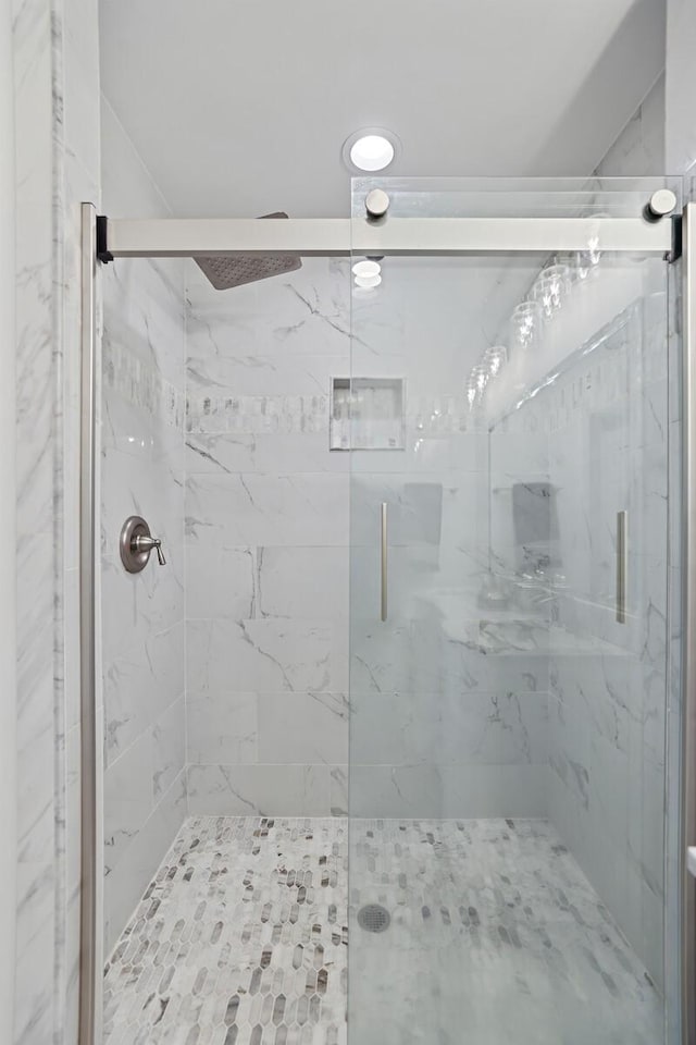 full bathroom featuring a marble finish shower