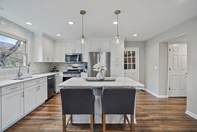 kitchen with white cabinets, appliances with stainless steel finishes, dark wood-type flooring, and a sink