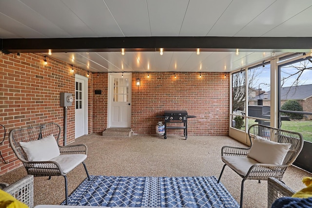 sunroom / solarium featuring beamed ceiling