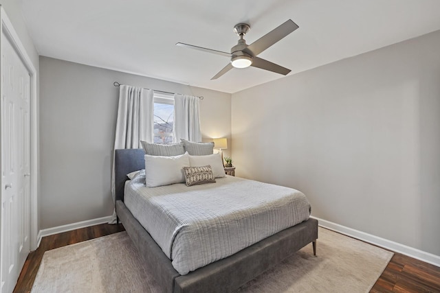 bedroom featuring a closet, ceiling fan, baseboards, and wood finished floors