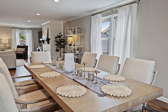 dining room with recessed lighting, baseboards, wood finished floors, and crown molding