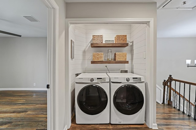 laundry area with visible vents, washer and clothes dryer, wood finished floors, baseboards, and laundry area