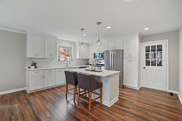 kitchen featuring a sink, stainless steel appliances, dark wood-type flooring, and white cabinetry