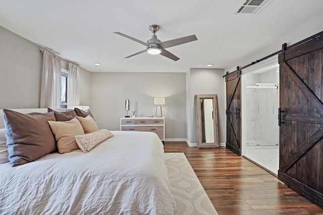 bedroom with visible vents, baseboards, a barn door, recessed lighting, and wood finished floors