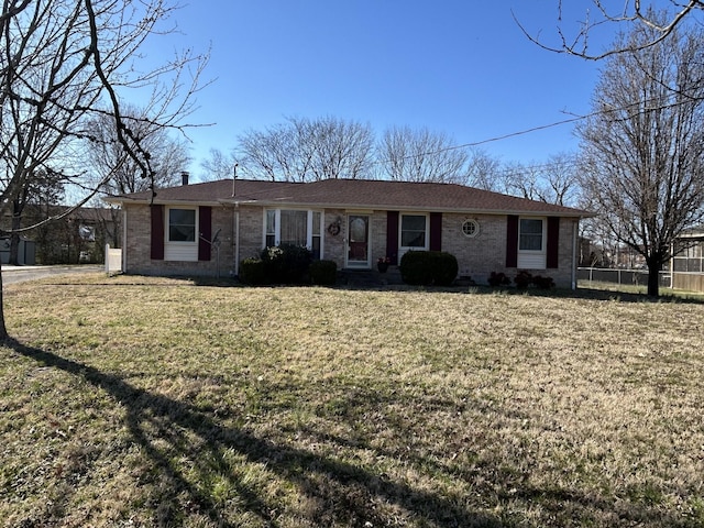 ranch-style home featuring brick siding, a front yard, and fence