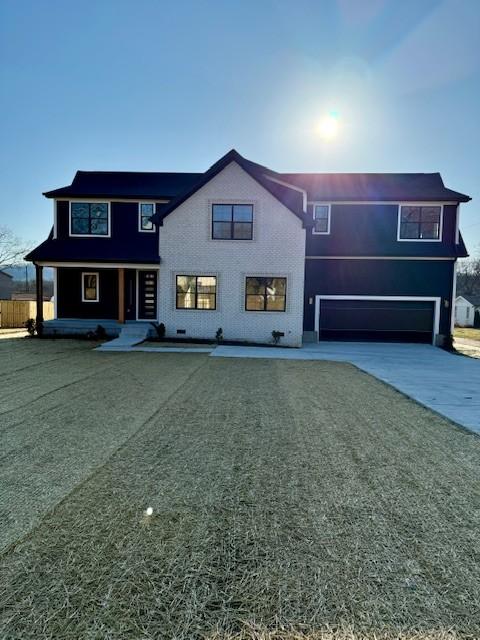 view of front of home featuring concrete driveway and an attached garage