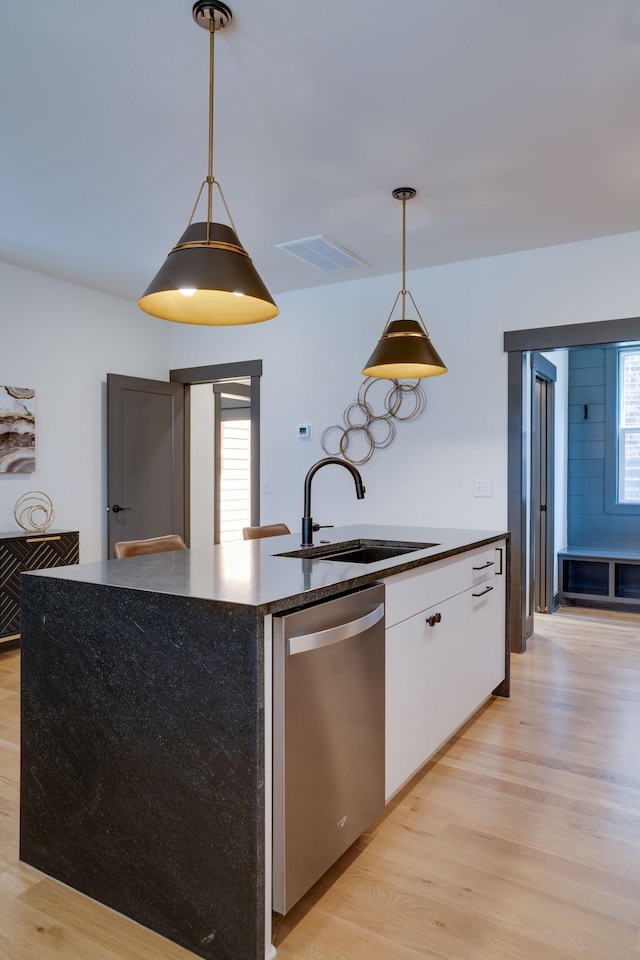 kitchen featuring dishwasher, white cabinets, light wood-style floors, and a sink