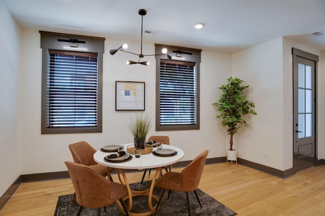 dining space with visible vents, baseboards, and light wood-type flooring