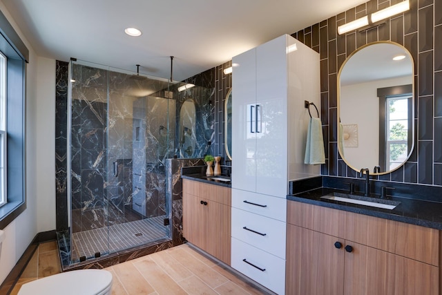 full bathroom featuring vanity, a marble finish shower, wood tiled floor, recessed lighting, and toilet