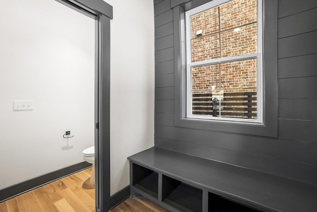 bathroom with toilet, wood finished floors, and baseboards