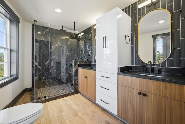 full bathroom featuring a marble finish shower, wood tiled floor, toilet, recessed lighting, and vanity