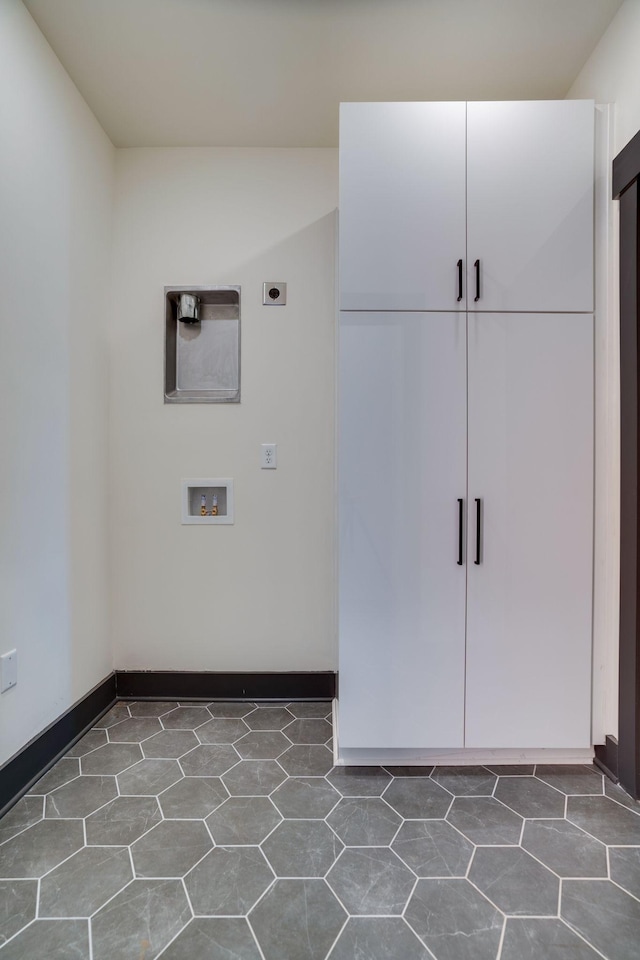 interior space with cabinet space, hookup for a washing machine, hookup for an electric dryer, and baseboards