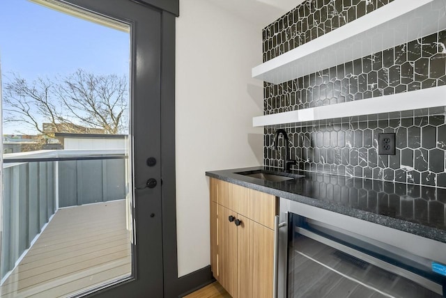 bar with decorative backsplash, wine cooler, indoor wet bar, and a sink