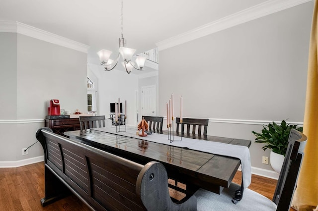 dining room with baseboards, a notable chandelier, wood finished floors, and ornamental molding