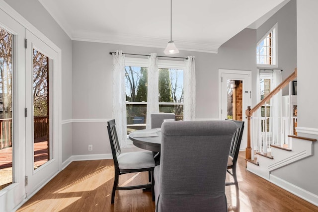 dining space featuring stairway, crown molding, baseboards, and wood finished floors