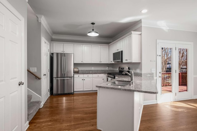 kitchen with dark wood-type flooring, appliances with stainless steel finishes, a peninsula, and white cabinetry