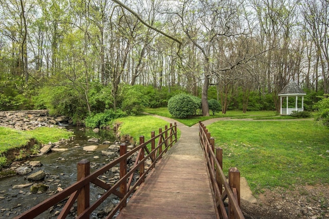 view of community featuring a gazebo, a yard, and a view of trees