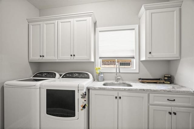 washroom with cabinet space, independent washer and dryer, and a sink