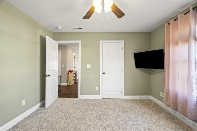 unfurnished bedroom with visible vents, baseboards, ceiling fan, and carpet flooring