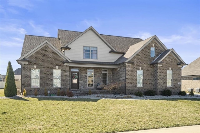 view of front of home with brick siding, roof with shingles, and a front lawn