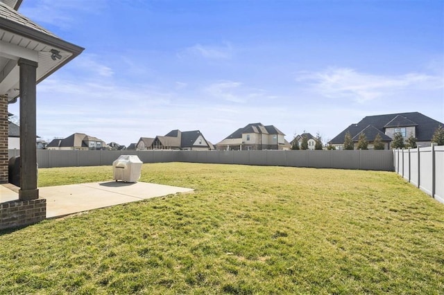 view of yard featuring a residential view, a patio, and a fenced backyard