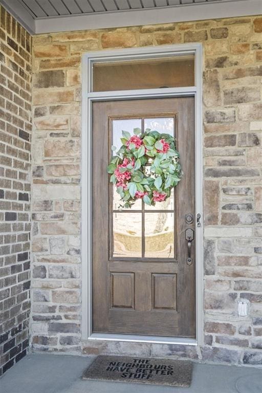 doorway to property with brick siding