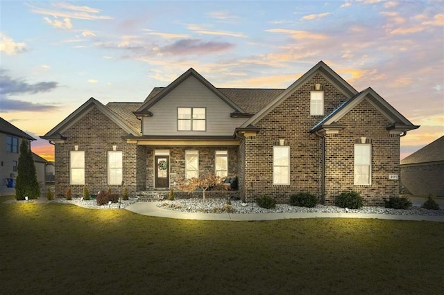 view of front of house featuring brick siding and a front lawn