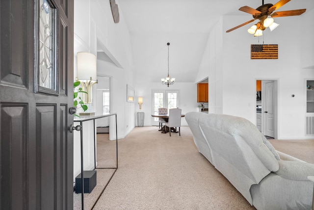 living room featuring visible vents, light colored carpet, an inviting chandelier, and high vaulted ceiling