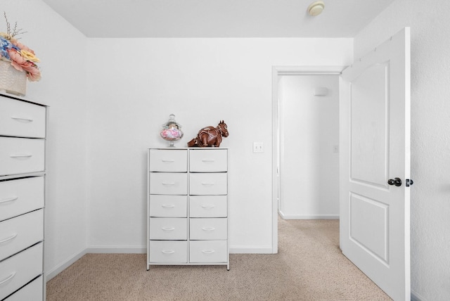 unfurnished bedroom with light carpet and baseboards