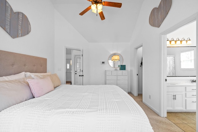 bedroom with baseboards, light colored carpet, ensuite bath, high vaulted ceiling, and a sink