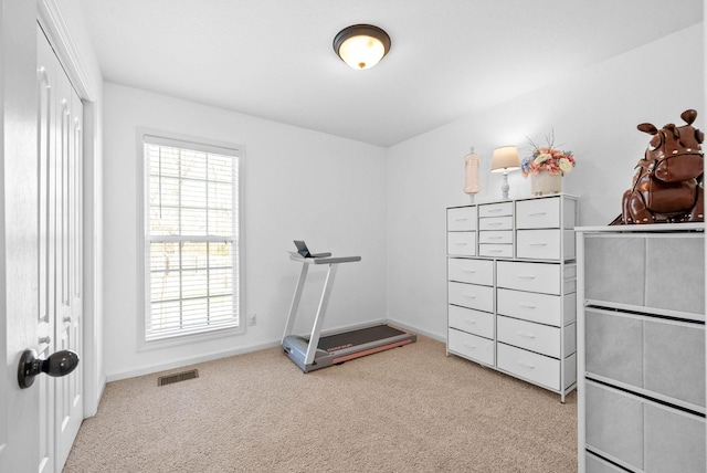 workout room with light colored carpet, visible vents, and baseboards