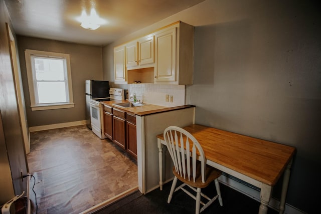 kitchen with tasteful backsplash, baseboards, white electric range, and a sink