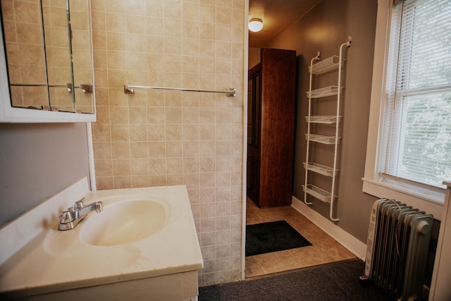 full bathroom featuring vanity, tile walls, radiator heating unit, and tile patterned flooring