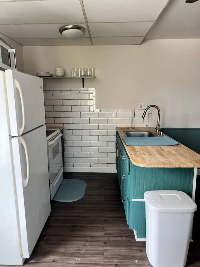 kitchen with butcher block countertops, a sink, a drop ceiling, blue cabinetry, and white appliances