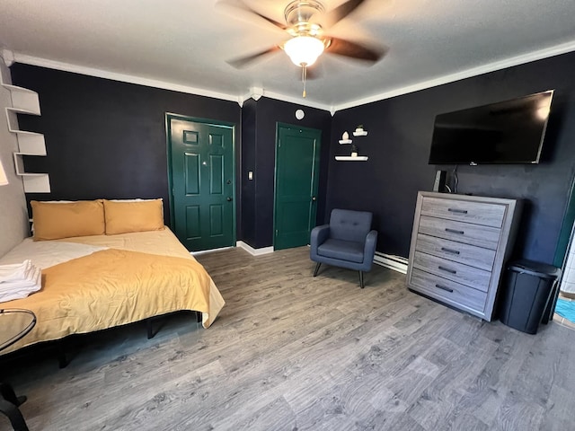 bedroom with baseboards, wood finished floors, a ceiling fan, and ornamental molding