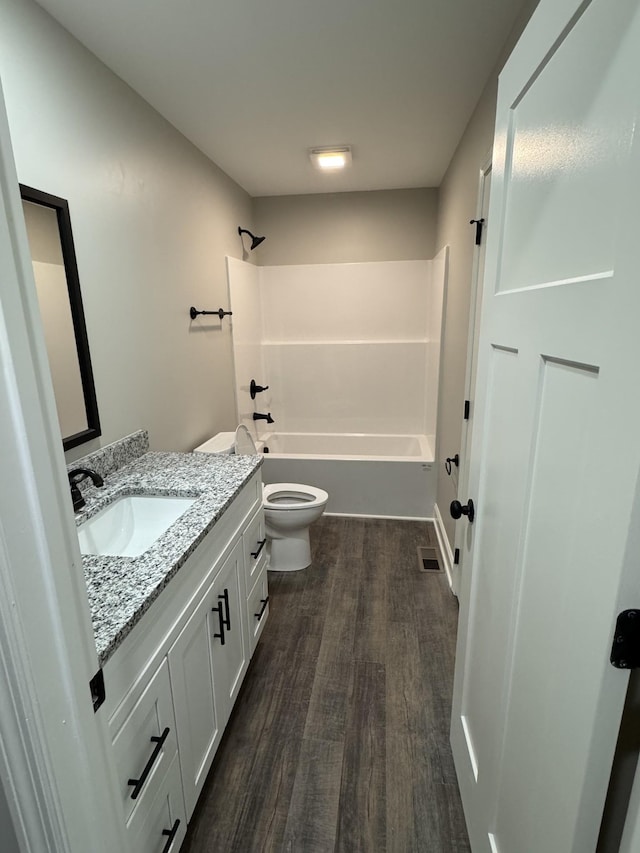 bathroom with visible vents, toilet, wood finished floors, bathtub / shower combination, and vanity