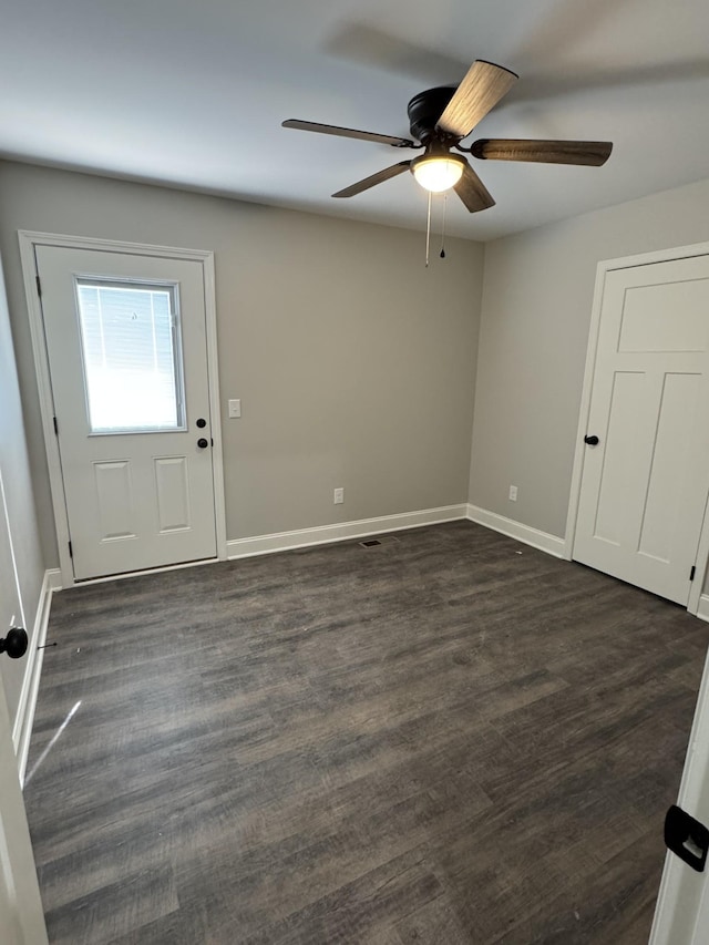 foyer entrance featuring a ceiling fan, baseboards, and dark wood-style flooring