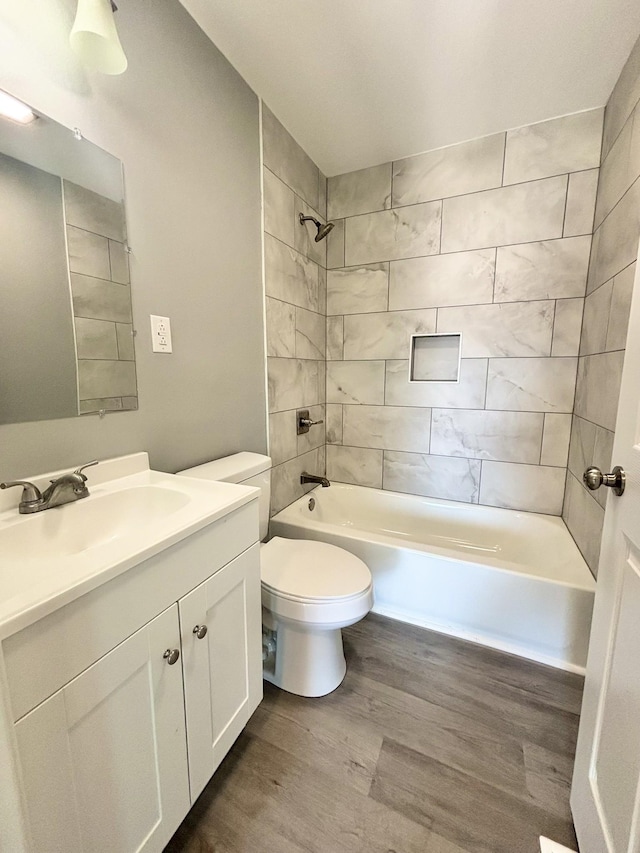 full bathroom featuring vanity, toilet, wood finished floors, and bathtub / shower combination