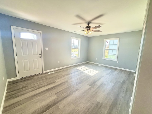 foyer entrance featuring wood finished floors, visible vents, and baseboards