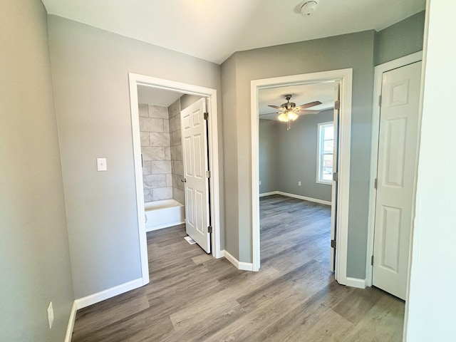 hall with wood finished floors and baseboards