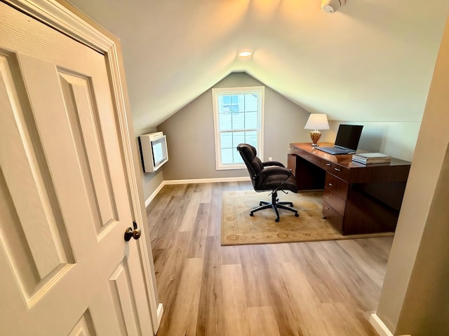 office featuring heating unit, baseboards, lofted ceiling, and light wood-style floors