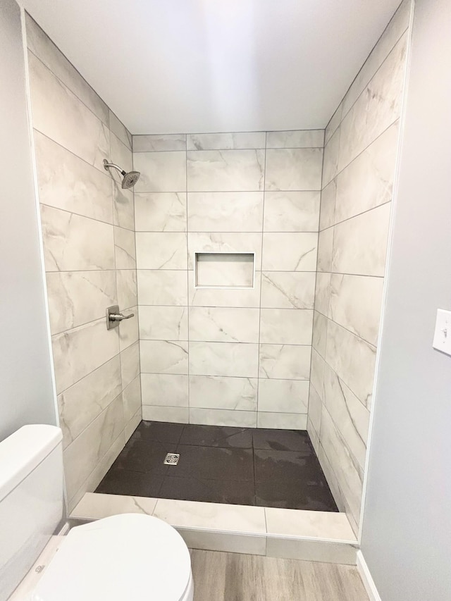 bathroom with toilet and tiled shower