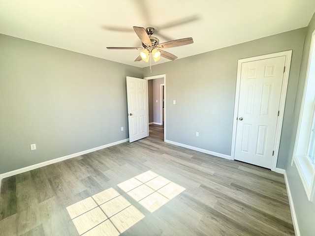 unfurnished bedroom featuring ceiling fan, baseboards, and light wood-type flooring