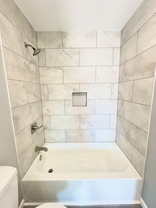 bathroom with shower / bathing tub combination and toilet